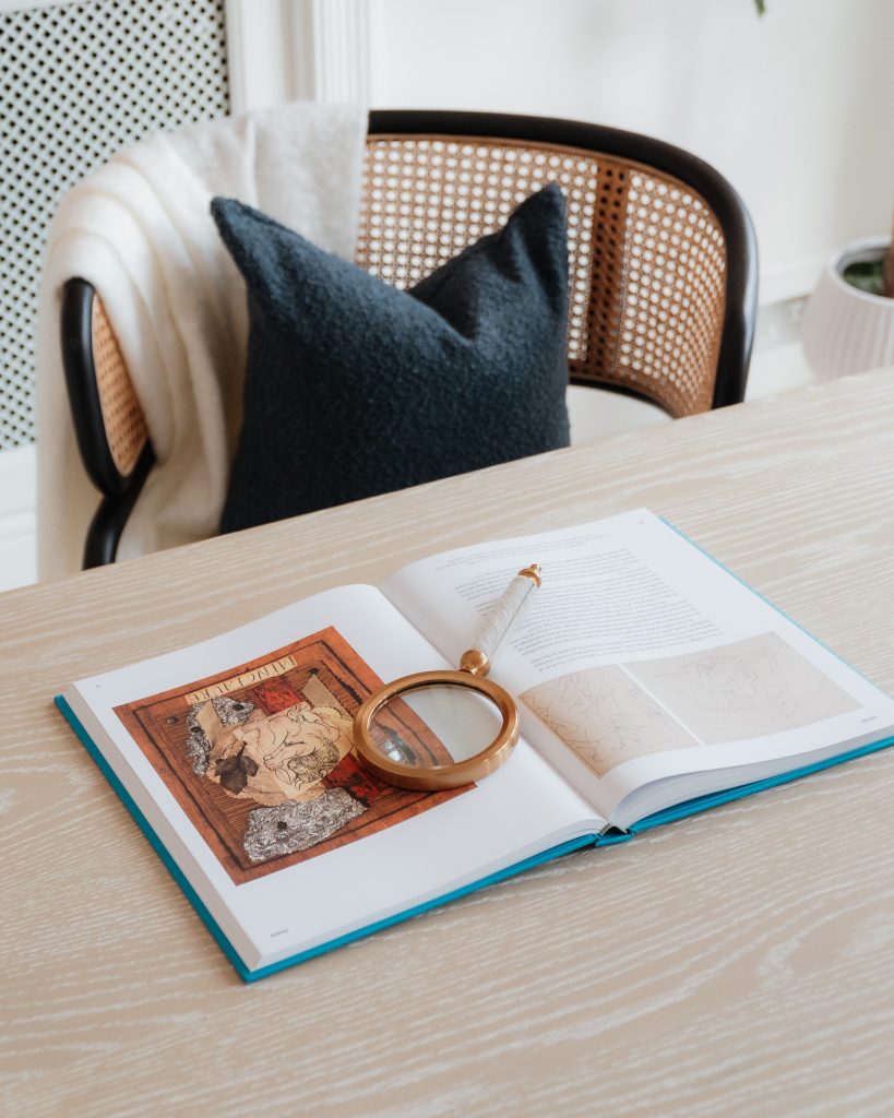 Art book and magnifying glass on desk ob-private-luxury-property-interior-content-production-36-studios.jpg Alt: OB Private luxury property interior content production by 36 Studios — styled desk with art book and brass magnifying glass