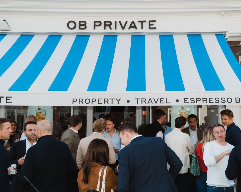 OB Private Notting Hill office launch exterior event photography by 36 Studios — branded blue and white striped awning with guests