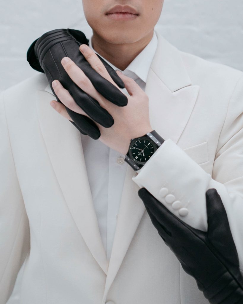 Hublot luxury watch campaign production by 36 Studios — model in white tailored suit with black leather gloves